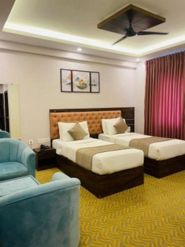 a hotel room with two beds and a couch at VOVO HOTELS in Yelahanka
