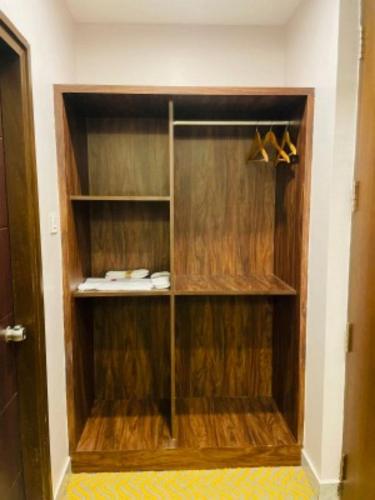 a walk in closet with wooden cabinets and shoes at VOVO HOTELS in Yelahanka