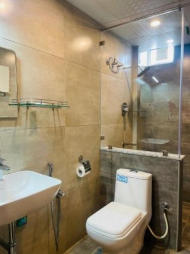 a bathroom with a toilet and a sink and a shower at VOVO HOTELS in Yelahanka
