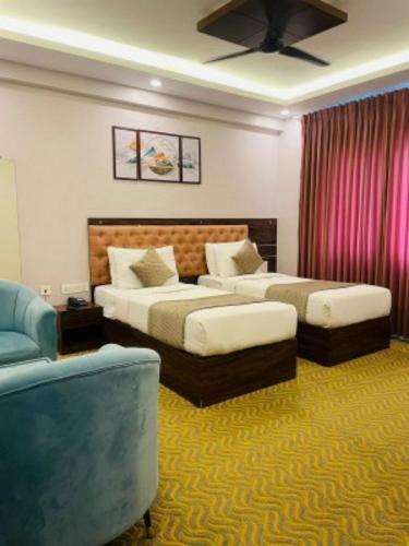 a hotel room with two beds and a couch at VOVO HOTELS in Yelahanka