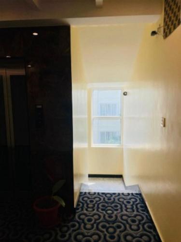 a room with a hallway with a window and a rug at VOVO HOTELS in Yelahanka