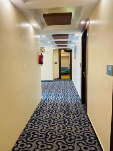 a hallway with a carpeted floor in a corridor at VOVO HOTELS in Yelahanka