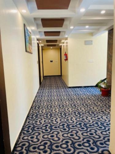 a hallway of an office building with a blue and white carpet at VOVO HOTELS in Yelahanka