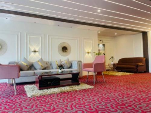 a living room with a couch and two chairs at VOVO HOTELS in Yelahanka