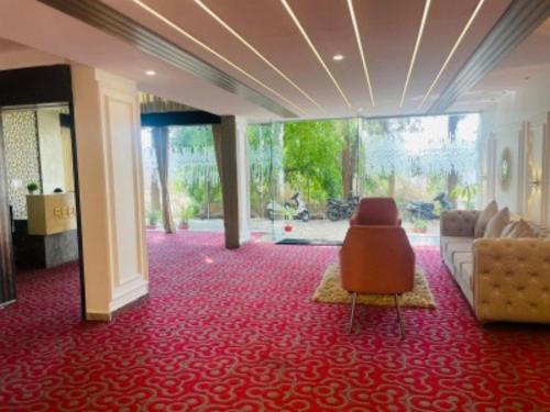 a lobby with a couch and a chair on a red carpet at VOVO HOTELS in Yelahanka