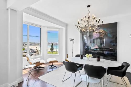 a dining room with a table and chairs and a chandelier at Bondi Beachfront Retreat - Beach views in Sydney