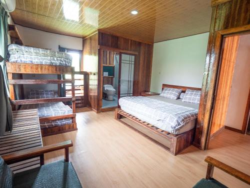 een slaapkamer met 2 stapelbedden en een badkamer bij Jamburae Lodge in Lagudri