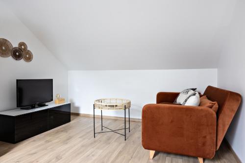 un salon avec un canapé marron et une table dans l'établissement undersky, à Chalon-sur-Saône