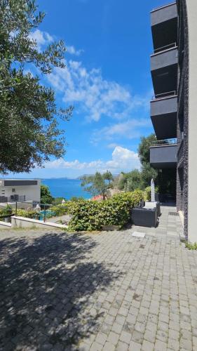 a brick walkway next to a building with a tree at Residence Alpha Apartments in Cavtat