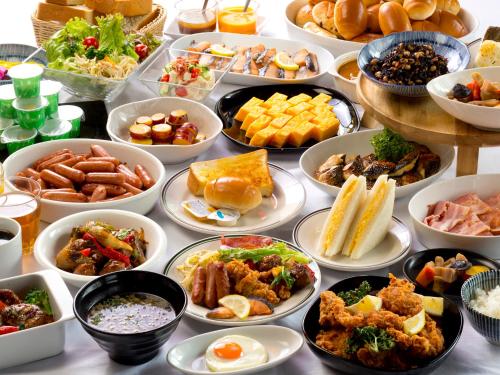 uma mesa cheia de diferentes tipos de alimentos em pratos em Hotel Hillarys em Osaka