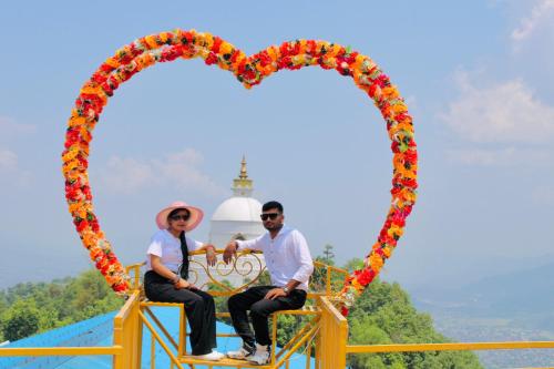 a couple sits in a heart shaped ride at a theme park at Mountain View cafe in Pokhara