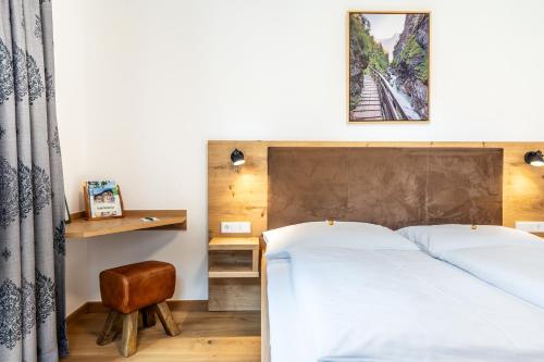 1 dormitorio con 1 cama, 1 mesa y 1 silla en Hotel-Garni Schernthaner, en Sankt Gilgen