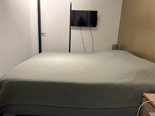 a bedroom with a bed with a flat screen tv on the wall at B&B Noordoostpolder in Emmeloord