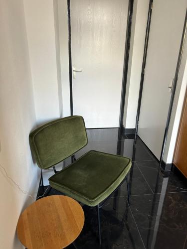 a green chair and a table in a room at B&B Noordoostpolder in Emmeloord