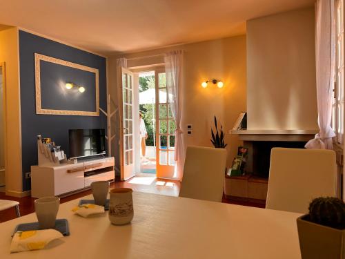 ein Wohnzimmer mit einem Tisch und einem TV in der Unterkunft Canevon Suite Apartment in Bardolino