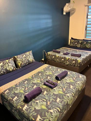 two beds with purple pillows on them in a room at MOM Darwin in Darwin