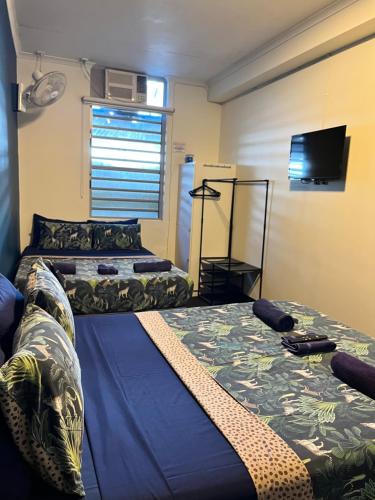 a room with two beds and a television in it at MOM Darwin in Darwin