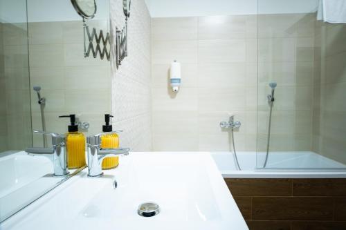 ein Badezimmer mit einem Waschbecken und einer Badewanne in der Unterkunft Elixír Panzió in Nyírbátor