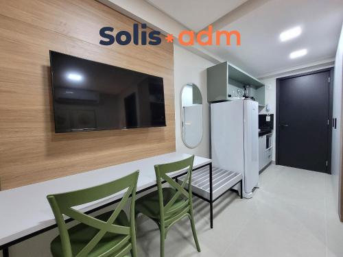 a kitchen with a dining table and a refrigerator at Way Bossa in Tambaú