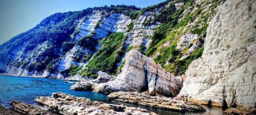 a mountain with rocks in the water next to the ocean at Vivi Conero in Ancona