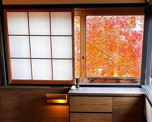 a kitchen with a window with a tree outside at arashiyama villa Serenitas kyoto 嵐山ヴィラ セレニタス京都 in Shimo saga