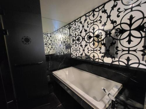 a bathroom with a sink and a black and white wall at Hotel Cullinan Wangsimni in Seoul