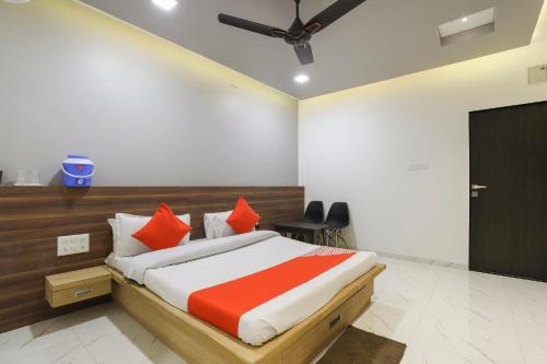 a bedroom with a bed with orange and white pillows at OYO KINGS HOTEL in Katunayake