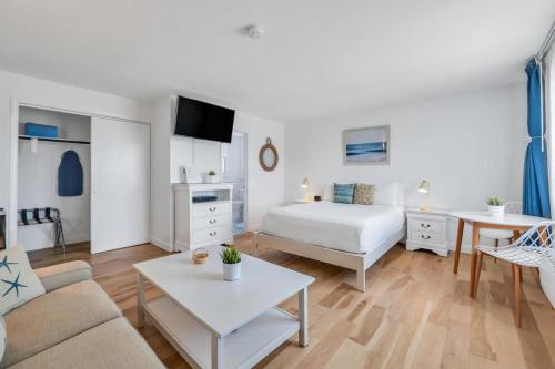 ein Schlafzimmer mit einem Bett und ein Wohnzimmer in der Unterkunft The Ocean Resort Inn in Montauk