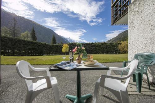 a table with two chairs and a table with wine glasses at Résidence Grands Montets 110 - Happy Rentals in Chamonix-Mont-Blanc