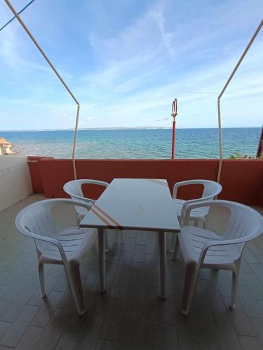 a table and chairs on a boat with the ocean at Nisaki chios apartments in Agia Ermioni