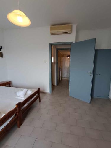 a room with a bed and an open door at Nisaki chios apartments in Agia Ermioni