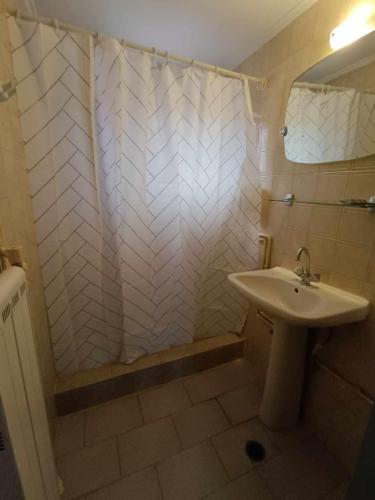 a bathroom with a sink and a shower with a mirror at Nisaki chios apartments in Agia Ermioni