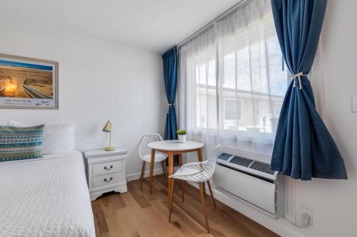 a bedroom with a bed and a table and a window at The Ocean Resort Inn in Montauk