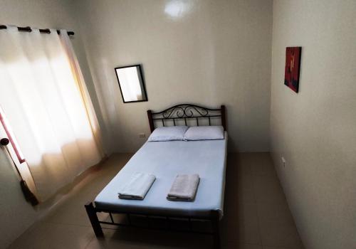 a bedroom with a bed with two towels on it at Bluewaves Resort - Basdaku by Hiverooms in Moalboal