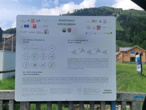 a sign on a fence with a house in the background at Aron Chalet Kreischberg 10A in Sankt Lorenzen ob Murau