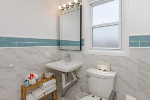 a bathroom with a sink and a toilet and a mirror at The Ocean Resort Inn in Montauk