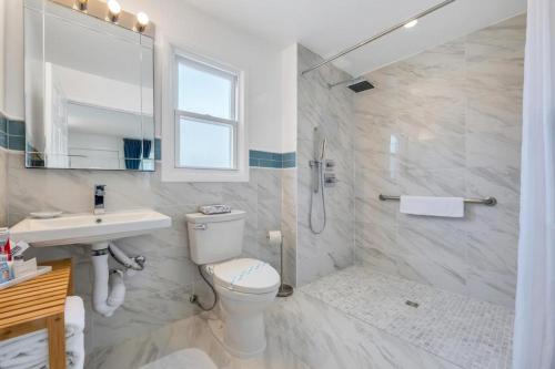 a bathroom with a toilet and a sink and a shower at The Ocean Resort Inn in Montauk