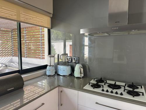 a kitchen with a stove top oven next to a window at Luxury holiday home 3 bedroom, 3 bathroom house in Nahoon in East London