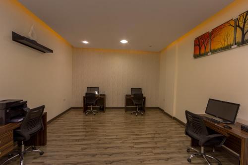 an office with three desks and chairs in a room at رؤوم ان للشقق الفندقية- Raoum Inn Hotel Apartments-Sakaka in Sakakah