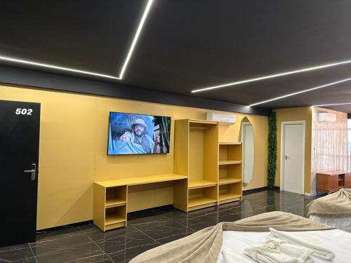 HOTEL NOVO CENTRO في بترولينا: غرفة مع تلفزيون على جدار أصفر