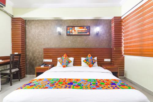 a bedroom with a large bed with a wooden headboard at FabHotel Royal Ville in Patna