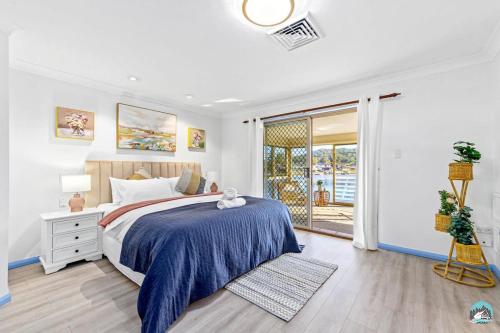 um quarto com uma cama e uma porta de vidro deslizante em Aircabin - Woy Woy - Water Front - 6 Beds Lux Home em Daleys Point