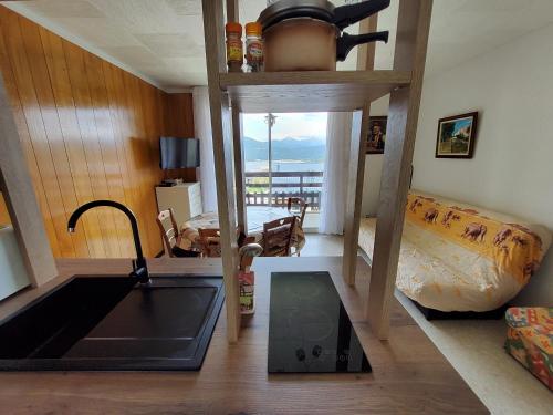 - une cuisine avec évier dans une chambre dotée d'un lit dans l'établissement Au coeur des Angles, aux Angles