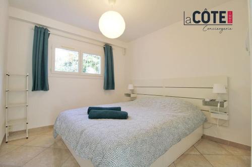 une chambre avec un lit avec un oreiller bleu dessus dans l'établissement Picasso, à Sausset-les-Pins