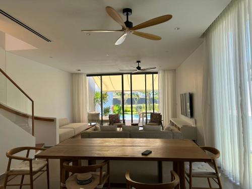 a living room with a table and a ceiling fan at 4BRs Villas at Ho Tram Sanctuary in Ho Tram