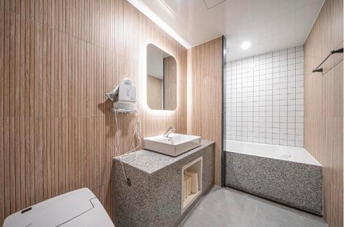 a bathroom with a sink and a toilet and a tub at Brown Dot Hotel Andong Ok-dong in Andong