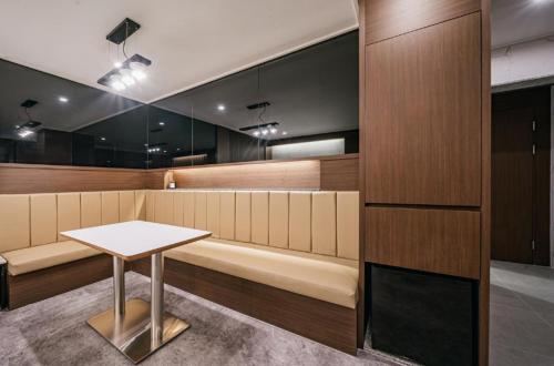 a dining room with a bench and a table at Brown Dot Hotel Andong Ok-dong in Andong