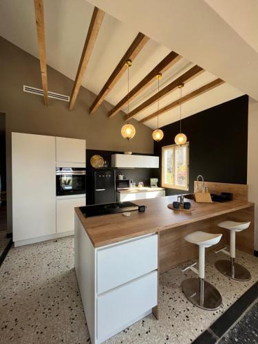 une cuisine avec un comptoir et deux tabourets dans l'établissement Magnifique! Idéal!, à Grosseto-Prugna