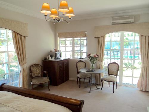 a bedroom with a bed and a table and chairs at Lanterns Retreats in Dunsborough