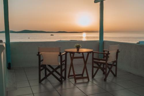 a table and chairs on a balcony with a view of the ocean at Sofia's Bungalows Mykonos in Mýkonos City